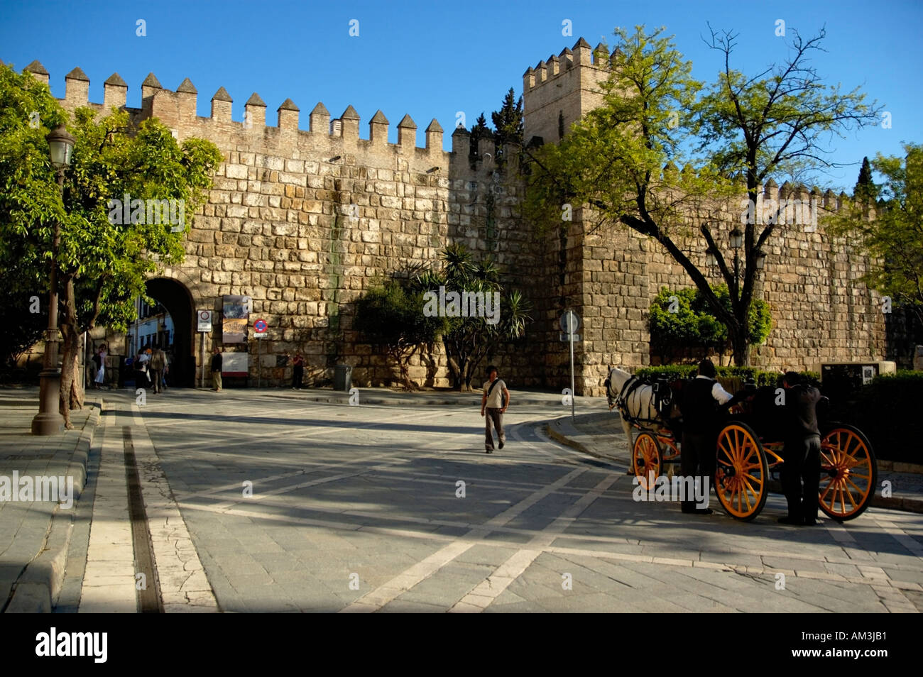 Horsedrawn cart waiting by stone wall in the Alcazar of Seville, Andalusia, Spain. Stock Photo