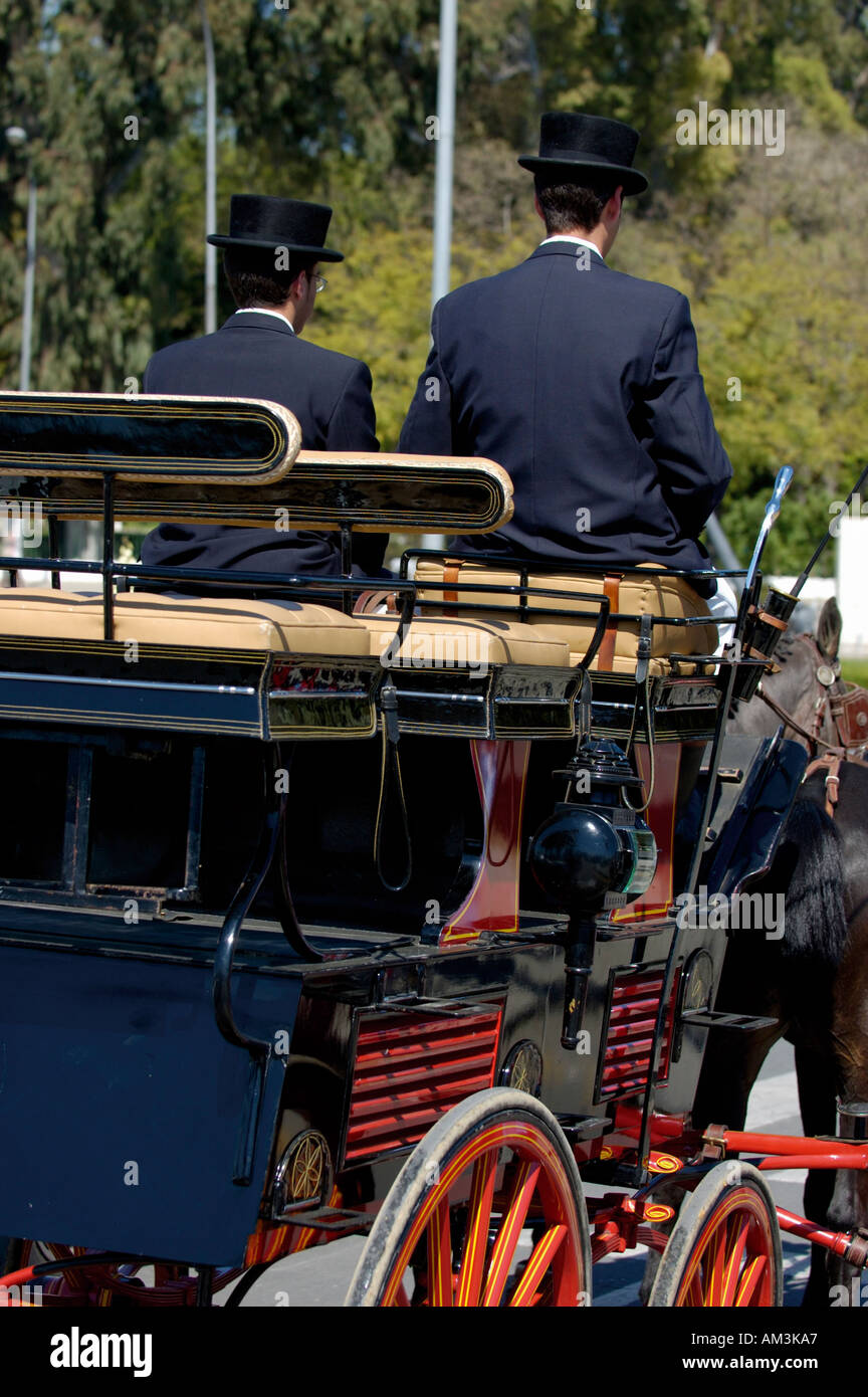 Two coachmen driving a barouche carriage during the Seville Spring Fair, Seville, Andalusia, Spain. Stock Photo