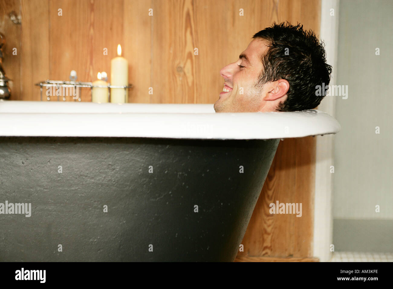 Man in roll top bath smiling Stock Photo