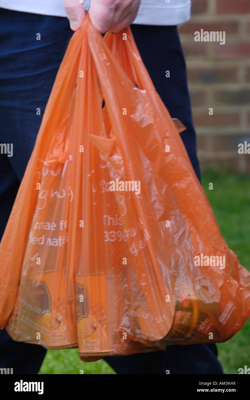 man with shopping in non degradeable supermarket plastic carrier bags
