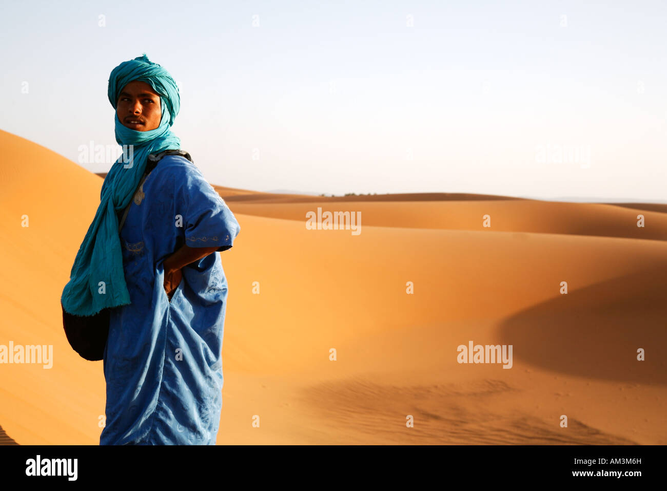Berber man in traditional blue dress standing in the Moroccan desert, North Africa. Stock Photo