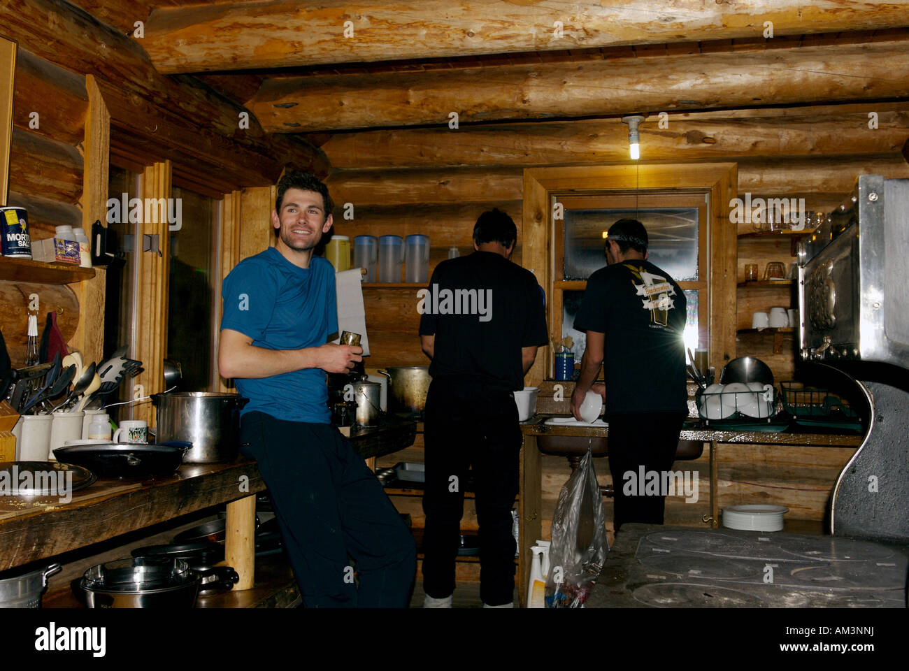 Washing dishes on a winter evening in a log cabin, Peter Estin Ski Hut, 10th Mountain Division Hut System, Colorado, USA. Stock Photo