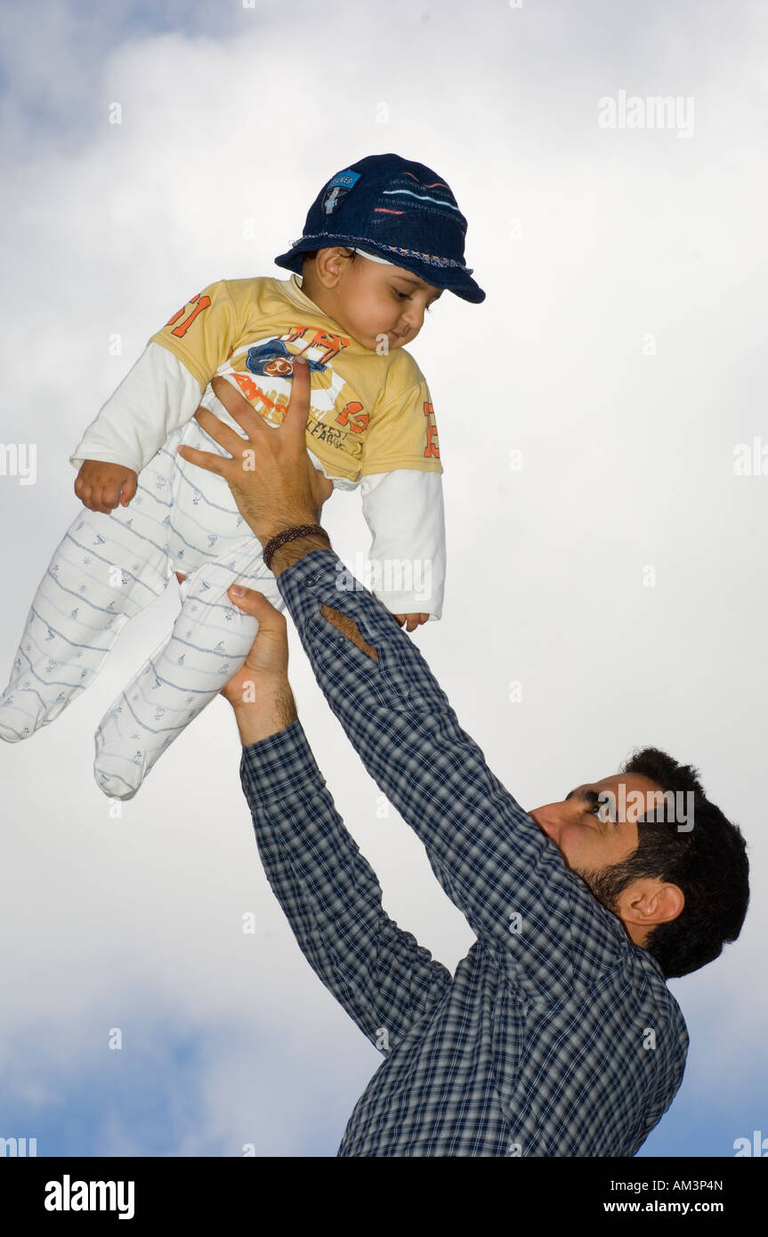 Man holding baby boy up Stock Photo