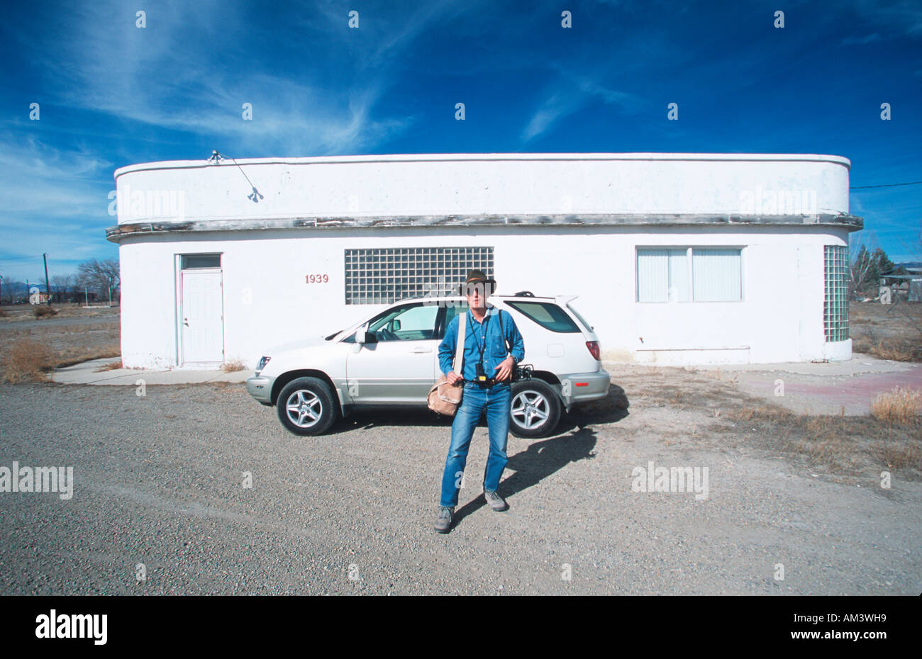 Joe Sohm the photographer posing with Lexus RX300 in front of deserted building in western states Stock Photo