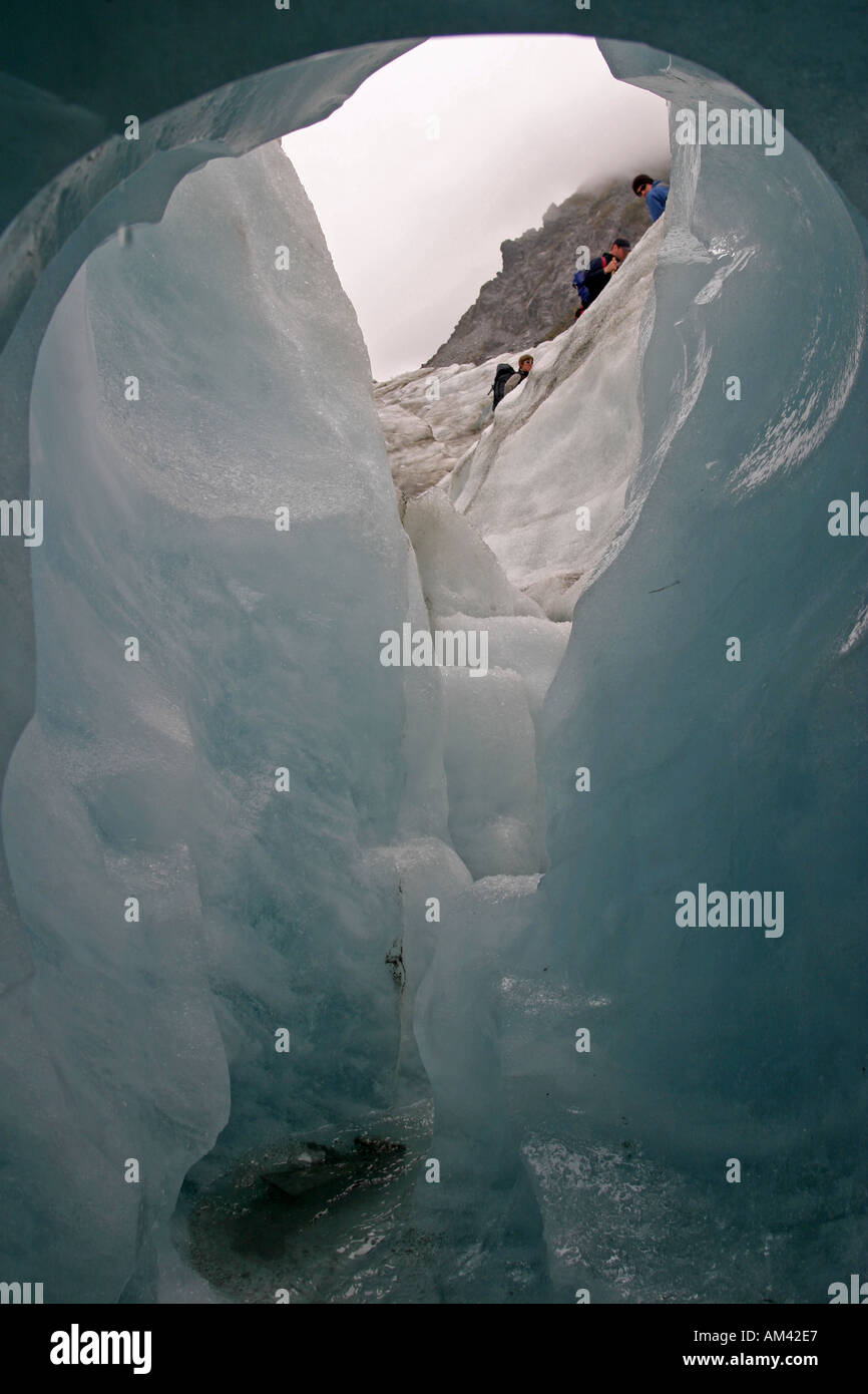 Hikers exit an ice cave on the Fox Glacier in the Mt Cook National Park