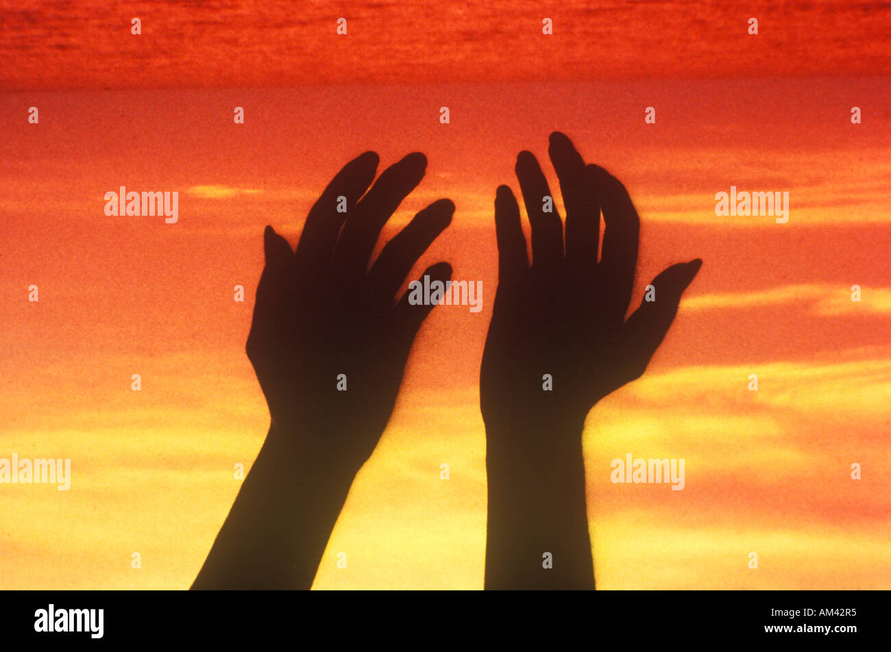 Sunset sky behind silhouette of two hands Stock Photo - Alamy