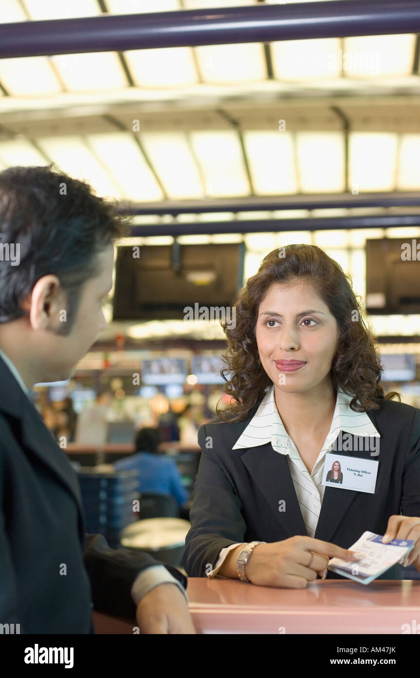 Businessman with an airline check-in attendant at an airport check-in counter Stock Photo