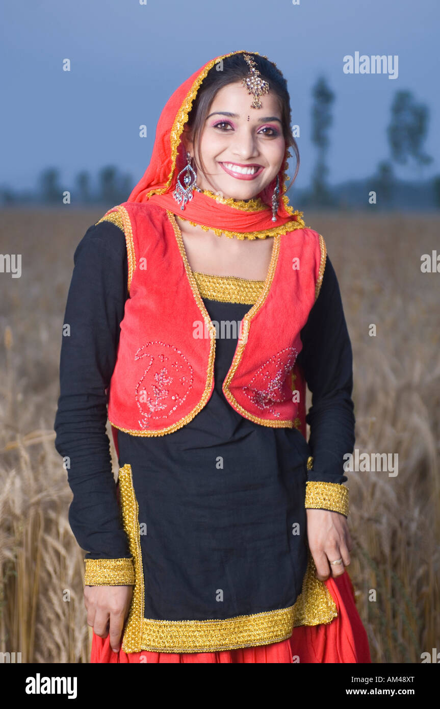 Portrait of a young woman standing in a wheat field and smiling Stock ...