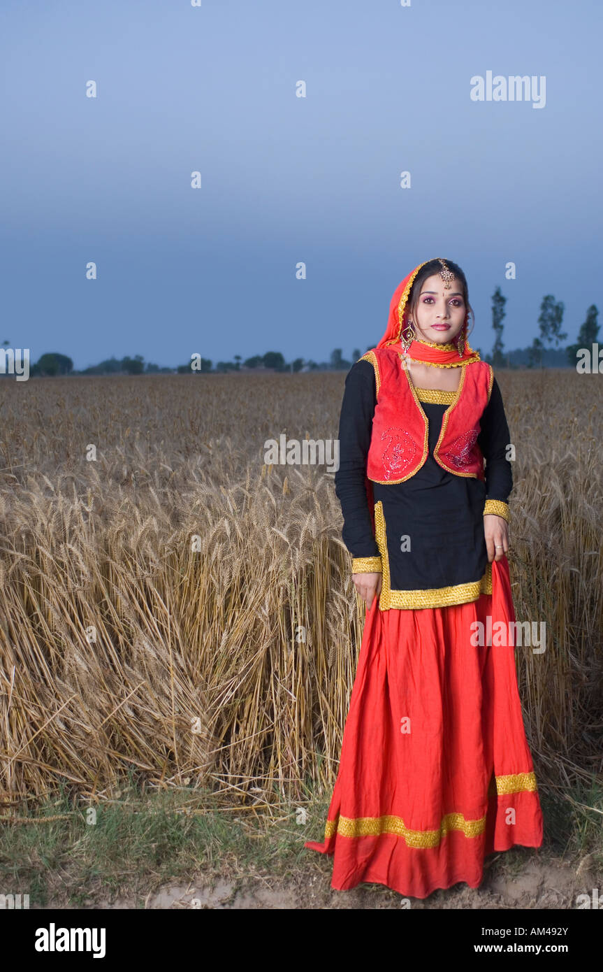 Portrait of a young woman standing in a wheat field Stock Photo - Alamy