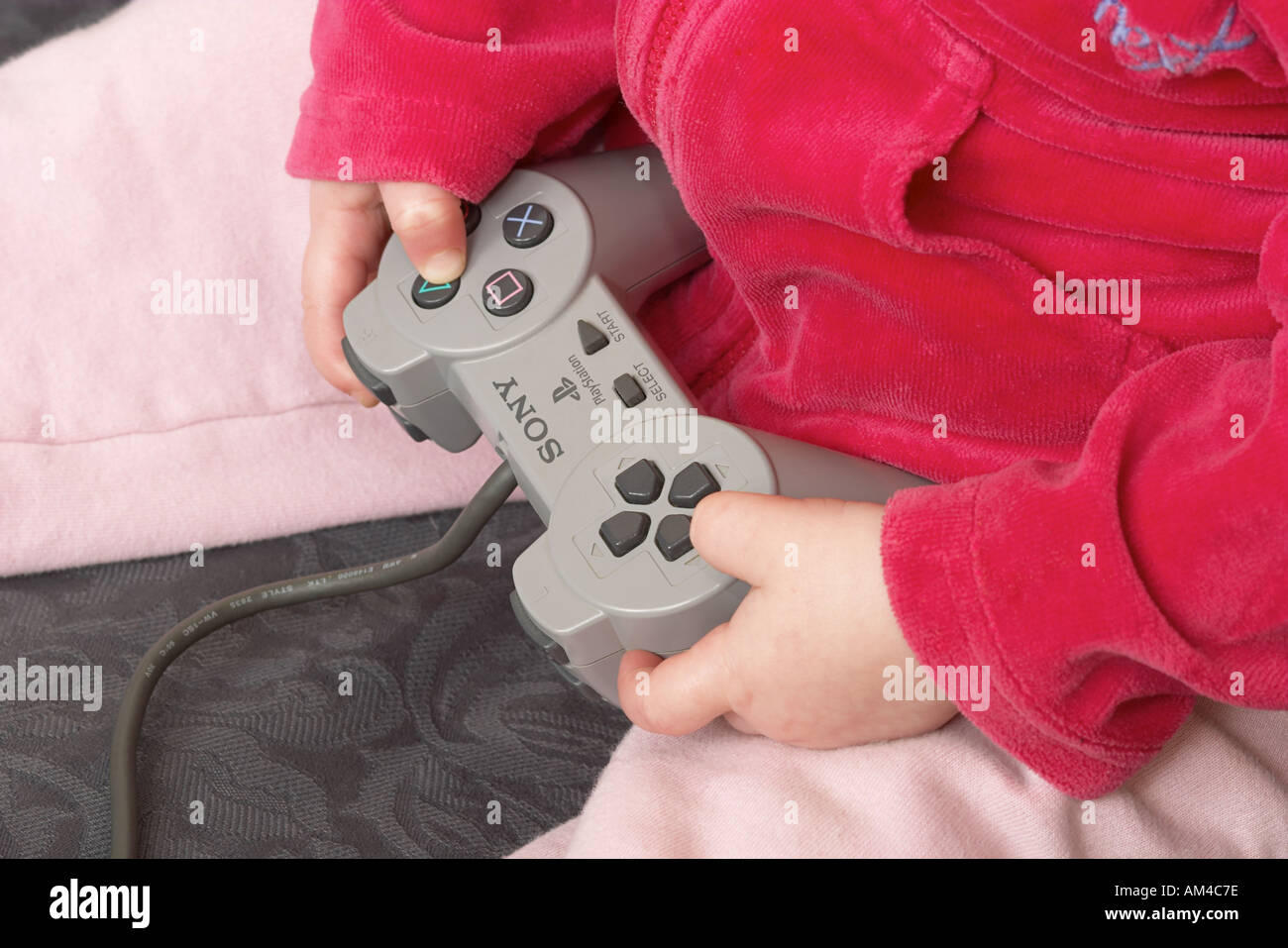 Close up of young girls hands using Sony Playstation controller Stock Photo