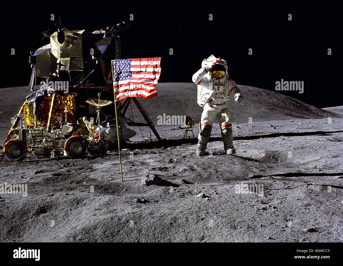 Apollo 16  Commander John Young jumps while saluting the flag. Stock Photo