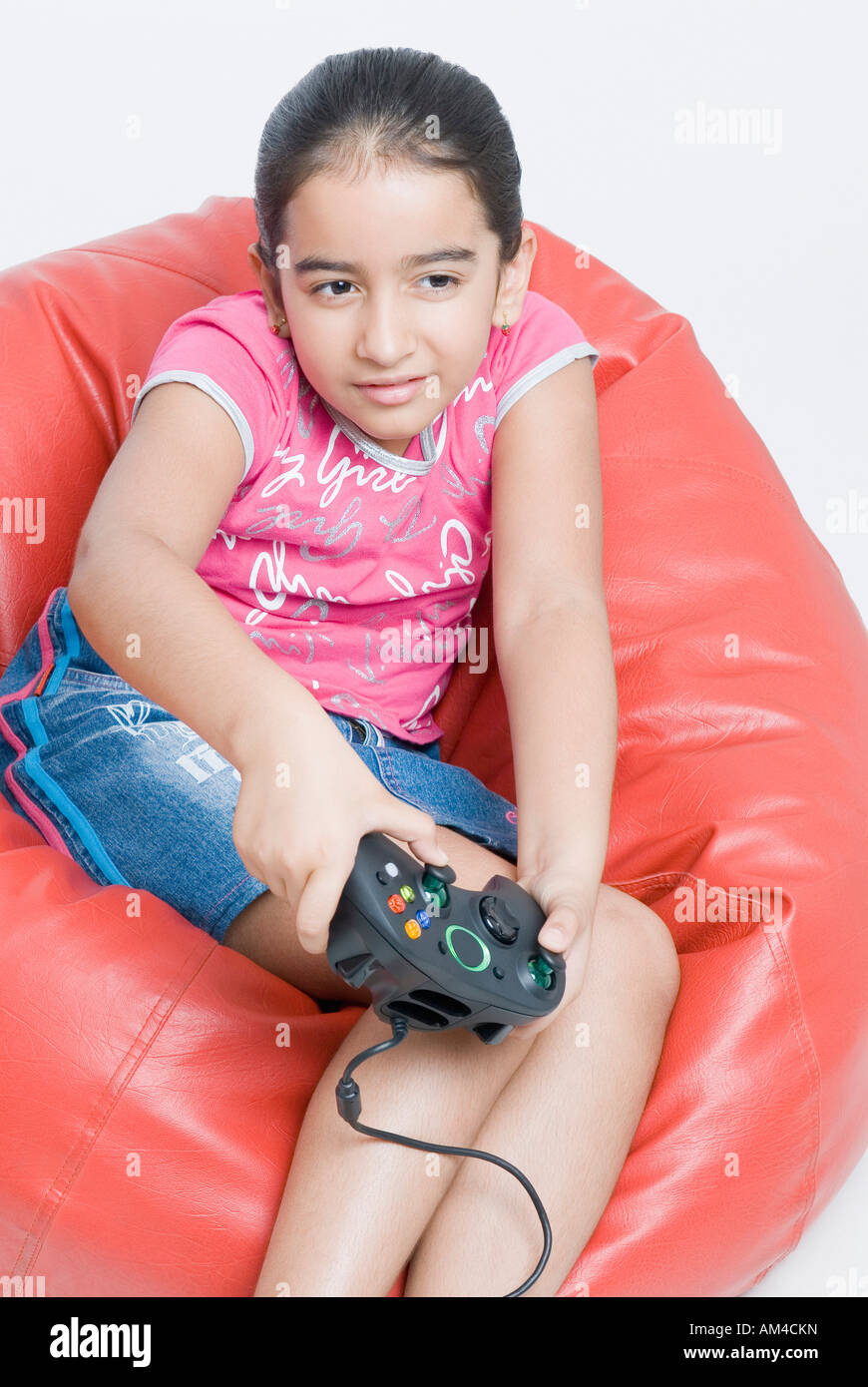 Close-up of a girl sitting on a bean bag and playing a video game Stock ...