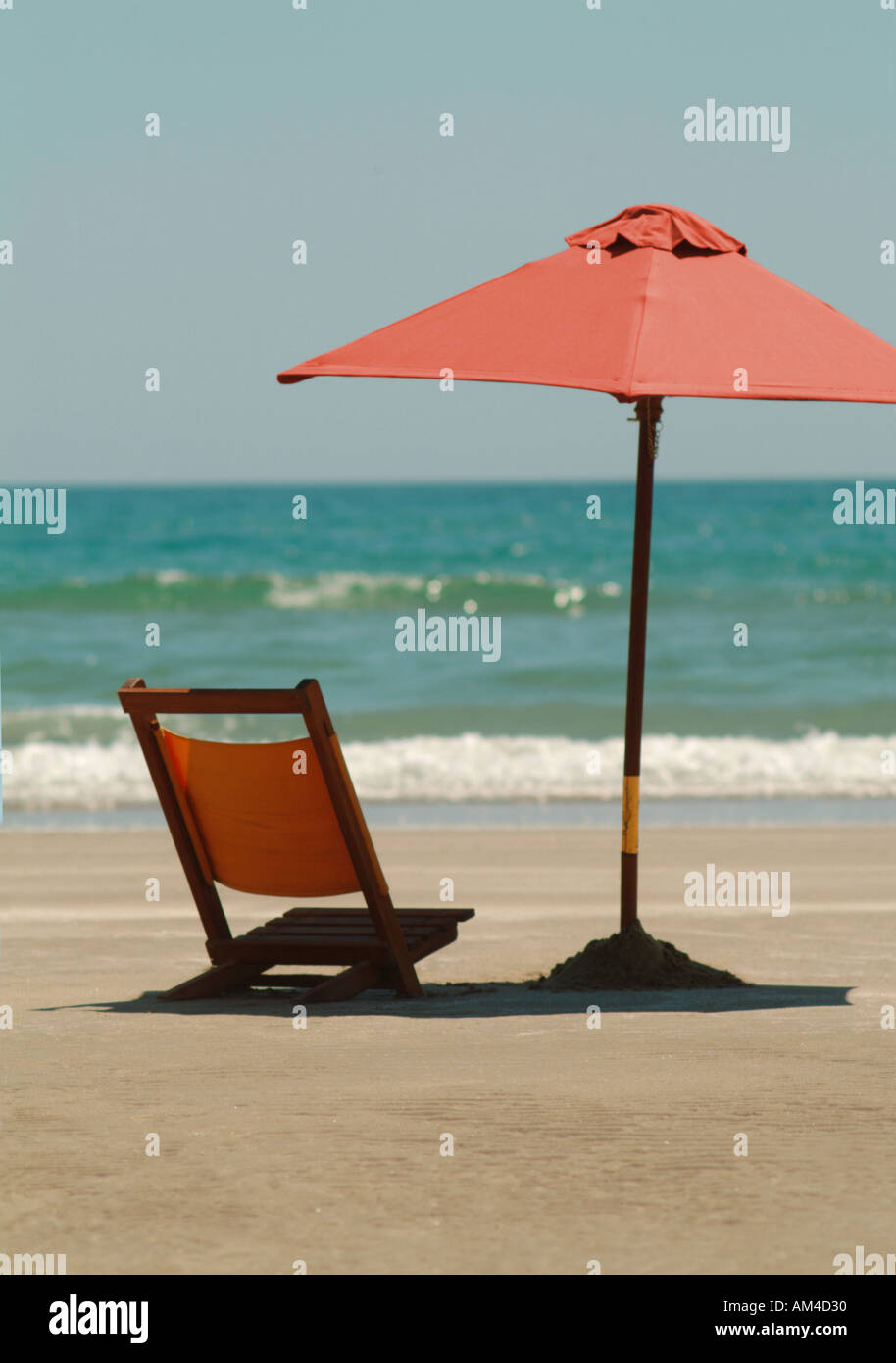 beach umbrella and chair on a sunny beach Stock Photo