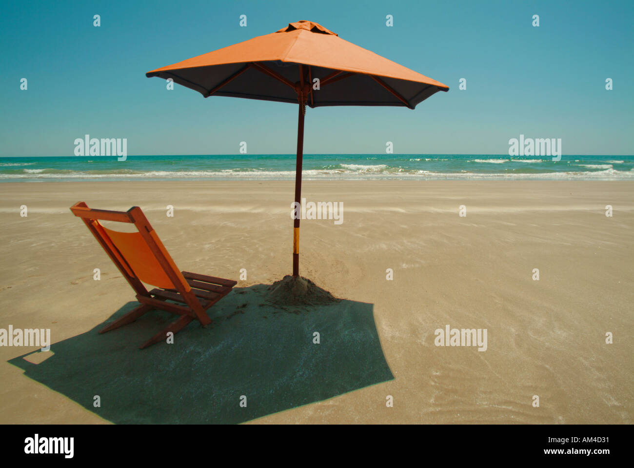 beach umbrella and chair on a sunny beach Stock Photo