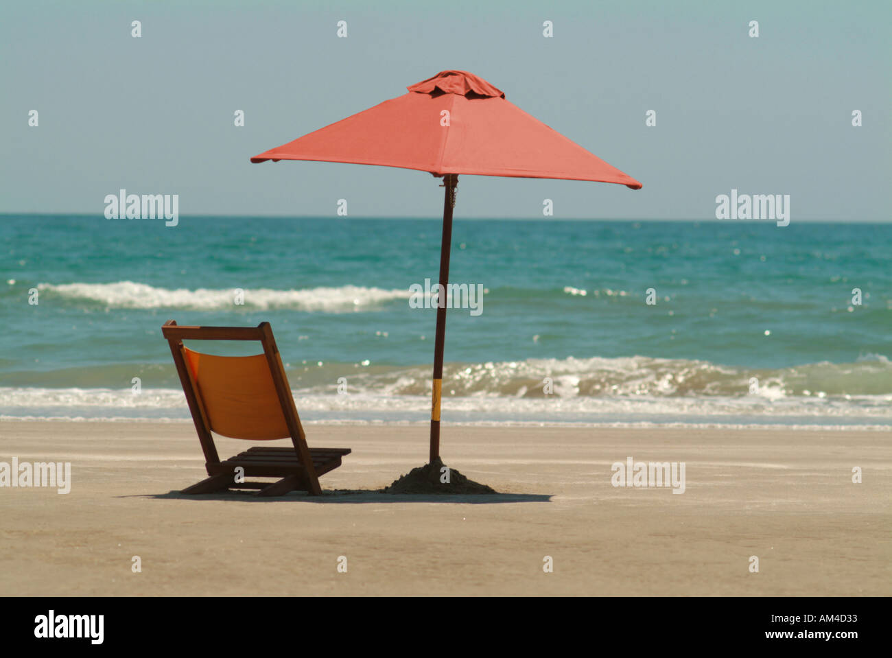 beach umbrella and chair on a sunny beach Stock Photo