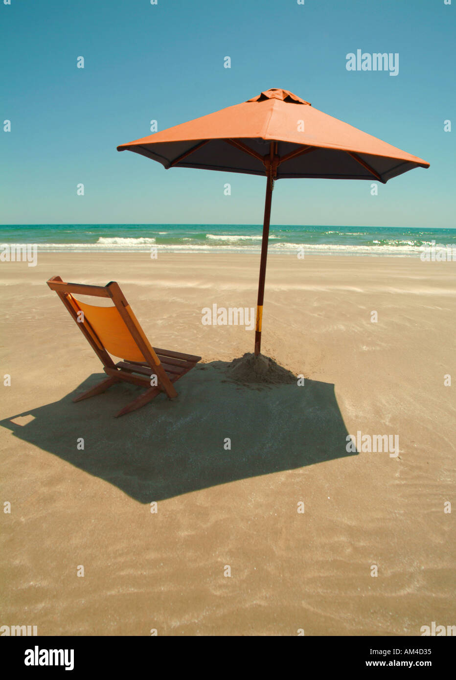 beach umbrella and chair on a sunny beach Stock Photo