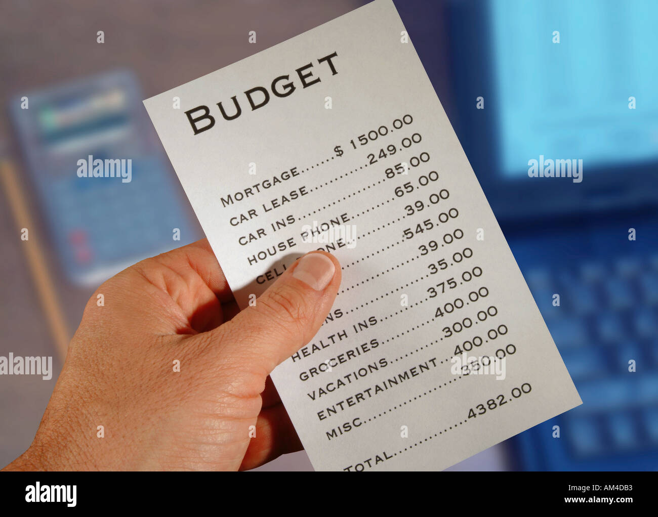 A man looks at his household budget printed out Stock Photo