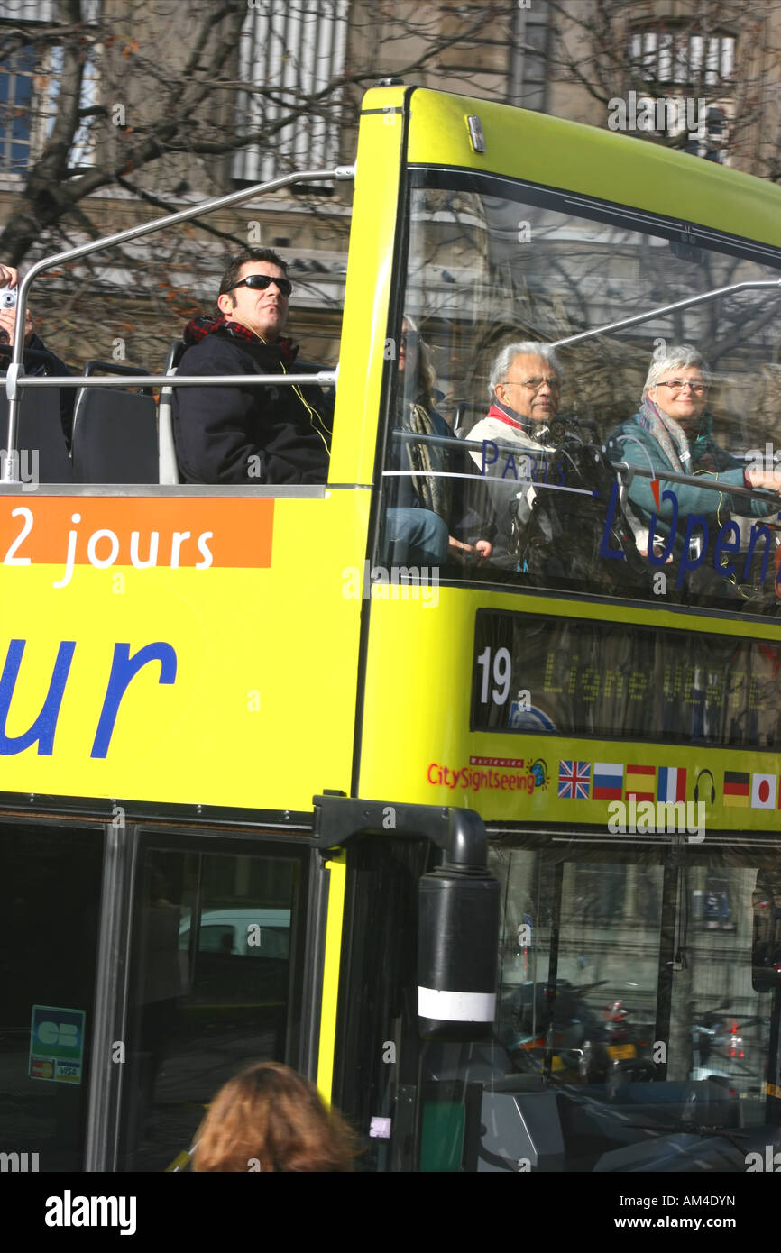 Tourists on an open-topped tour bus in Paris, France Stock Photo