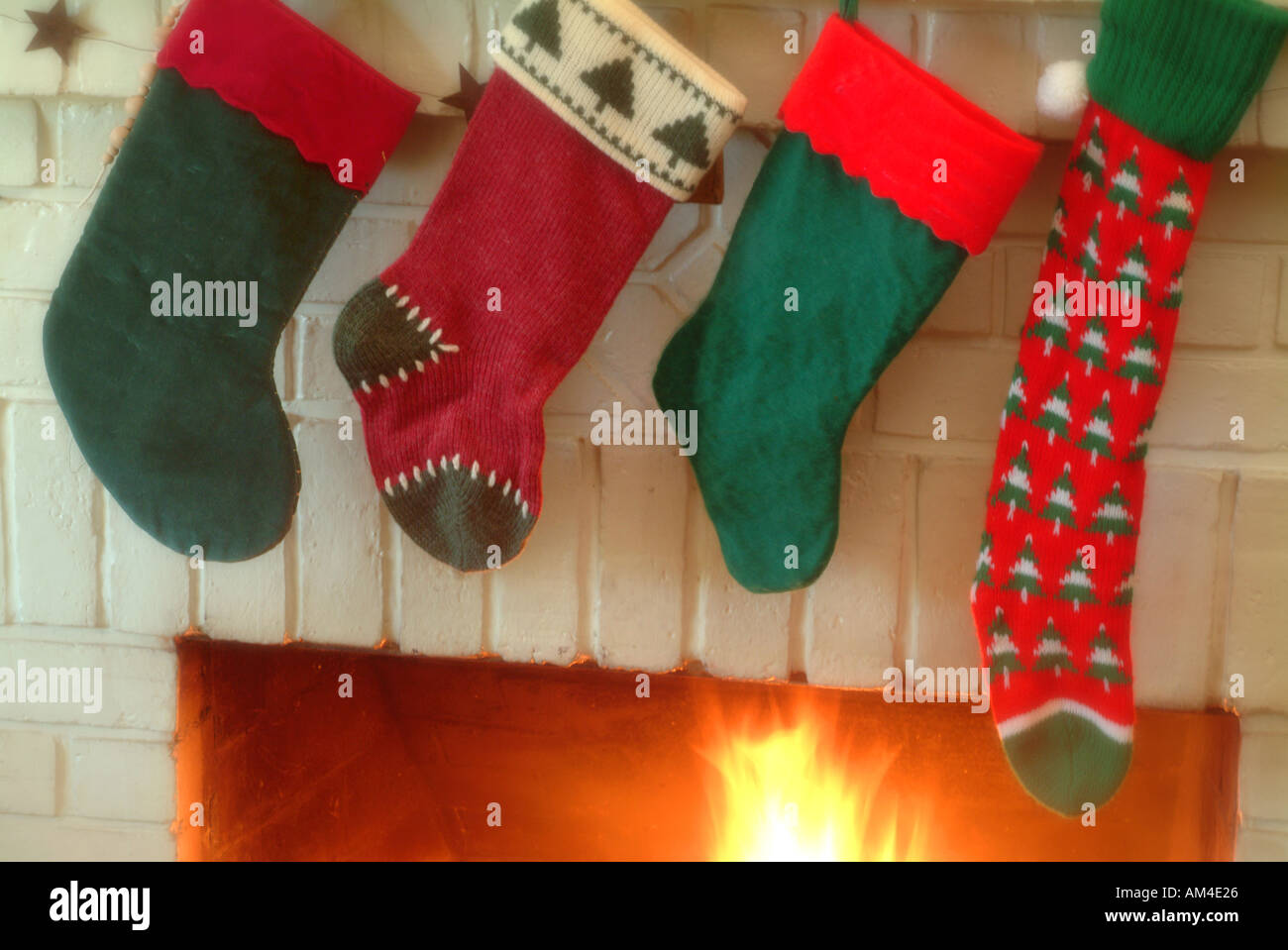 https://c8.alamy.com/comp/AM4E26/christmas-stockings-hung-on-the-mantle-with-care-a-fire-burns-in-the-AM4E26.jpg
