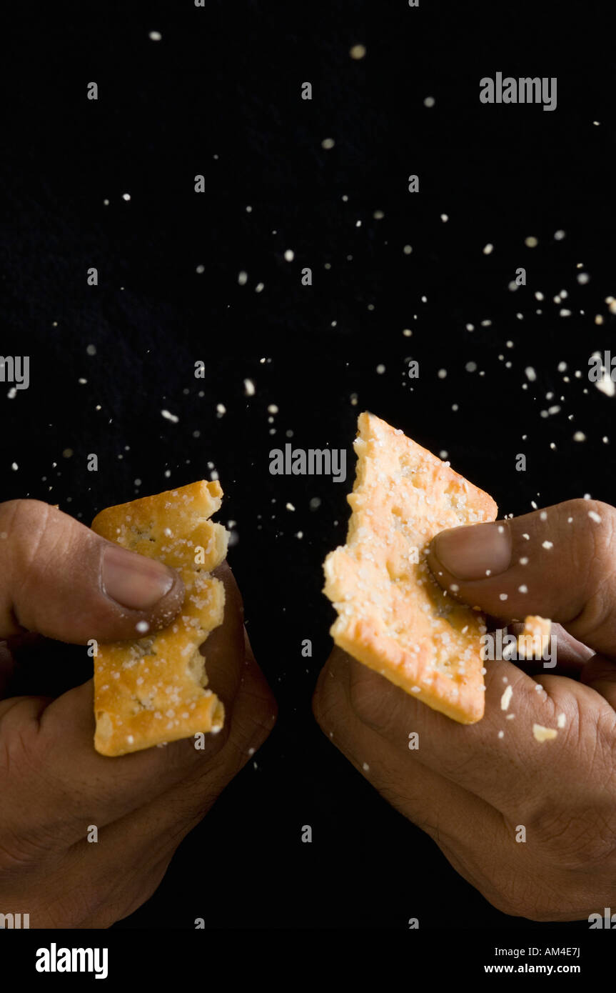 Closeup of a person's hand breaking a biscuit Stock Photo Alamy