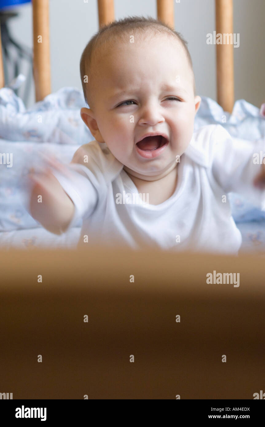 Baby boy crying in a crib Stock Photo Alamy