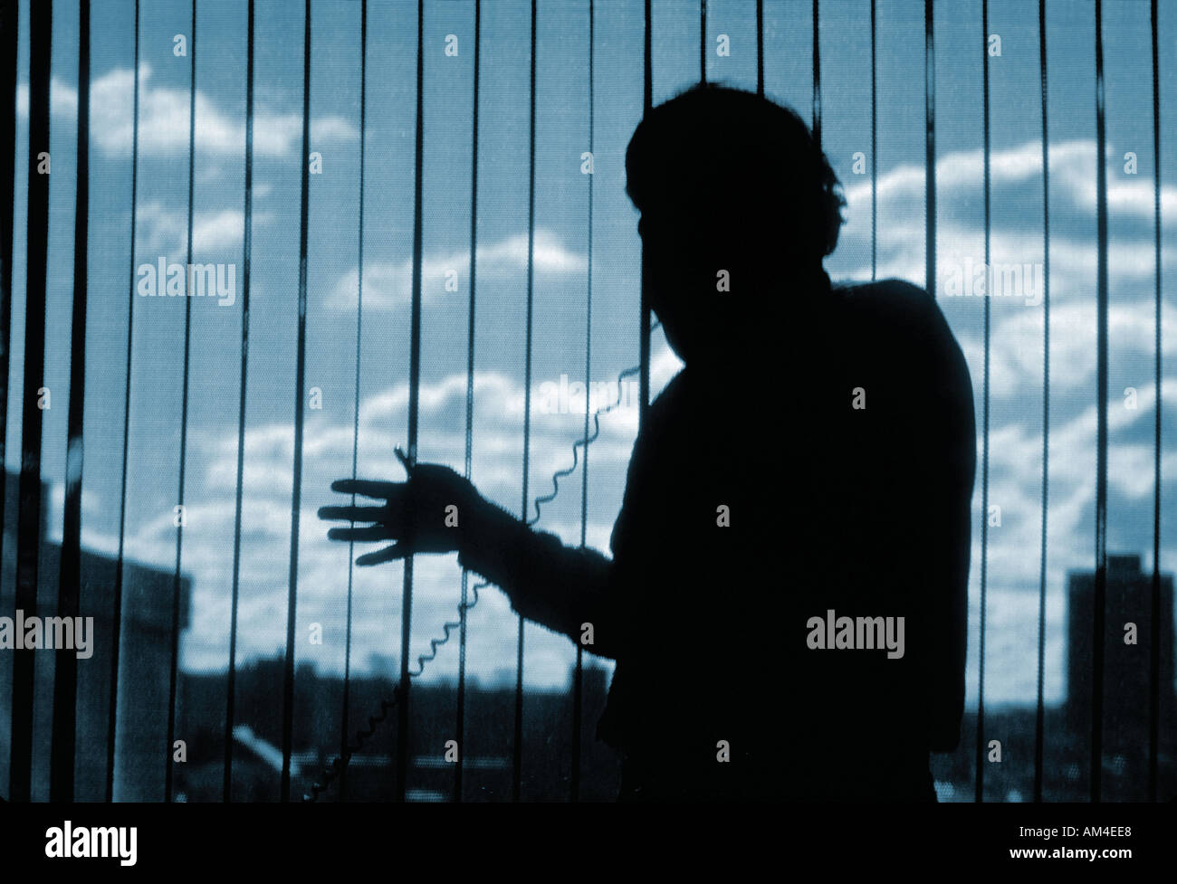 businessman on the phone silhouetted by the window light Stock Photo