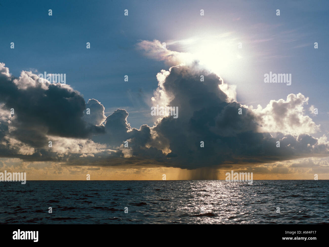 An isolated rain squall over the ocean on an otherwise sunny day Stock Photo