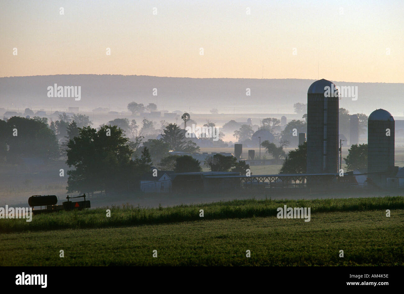 Amish and English farms in the early morning mist near Intercourse Pennsylvania USA in summer Stock Photo