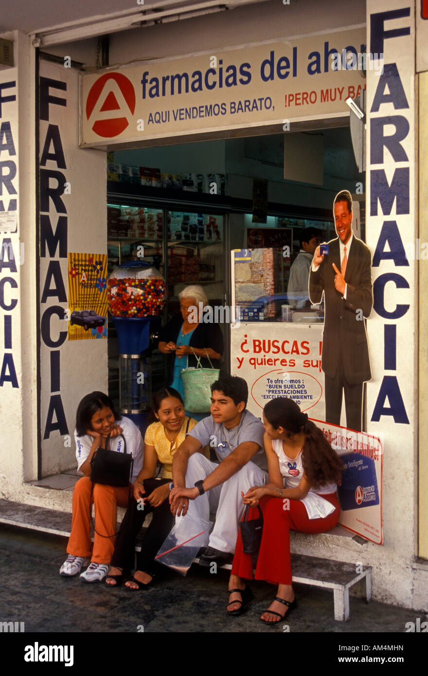 Mexican people sitting and talking in front of pharmacy along Calle Macedonio Alcala Street city of Oaxaca Oaxaca State Mexico Stock Photo