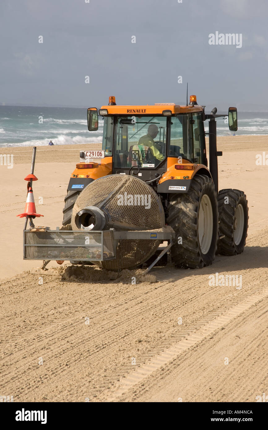 Tractor cleaning sand on beach to ensure the removal of any needles