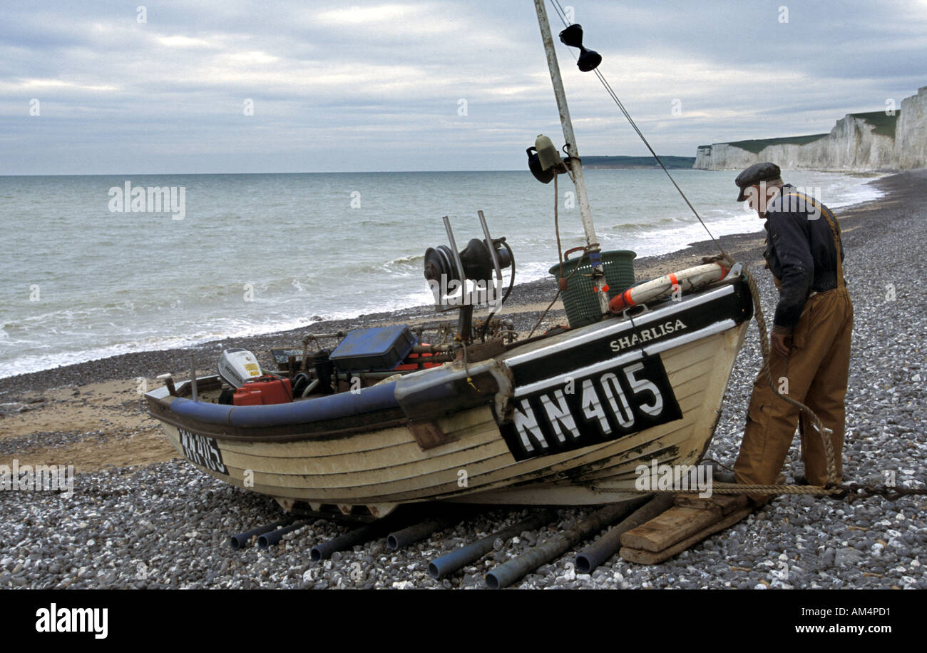 Cockle and Crab fisherman hauls his boat onto the beach at Birling Gap using an electric winch East Sussex England Stock Photo