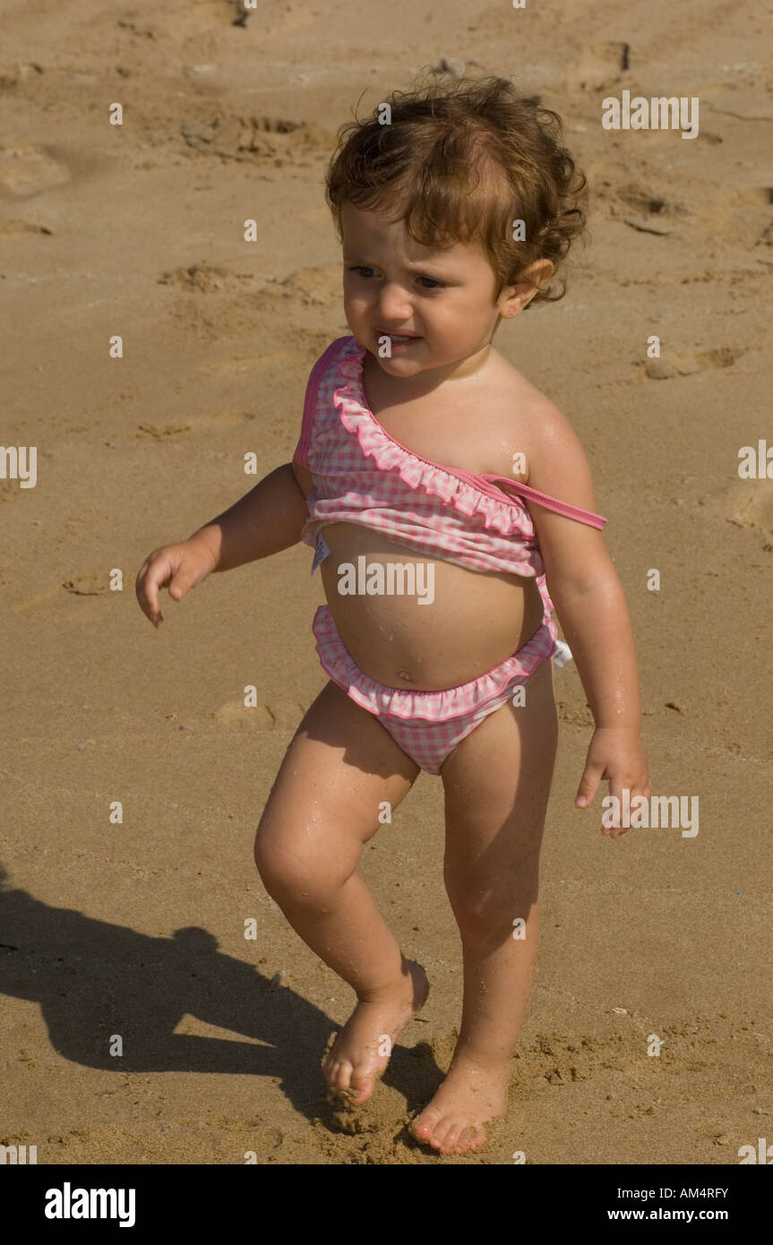 baby girl in pink bikini walking on the beach Stock Photo - Alamy