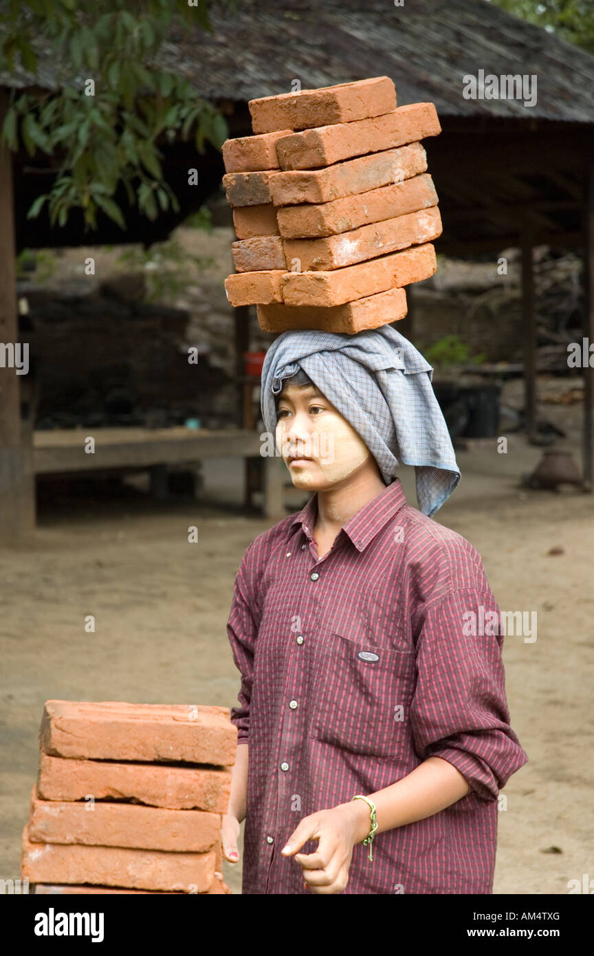 Woman carrying bricks on her head at a construction site in Bagan