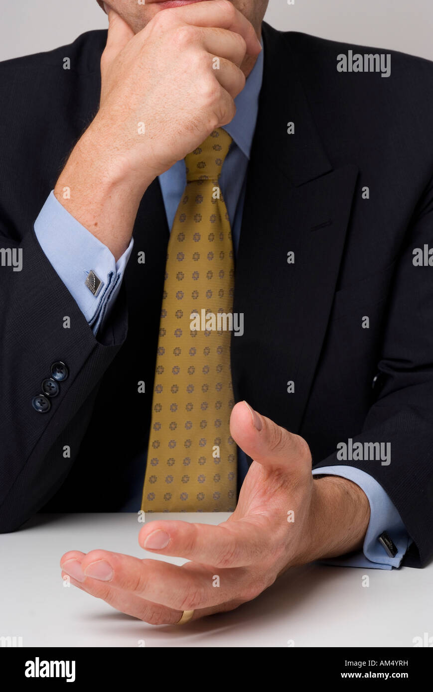 Close shot of business man sitting behind desk showing hand gestures Stock Photo