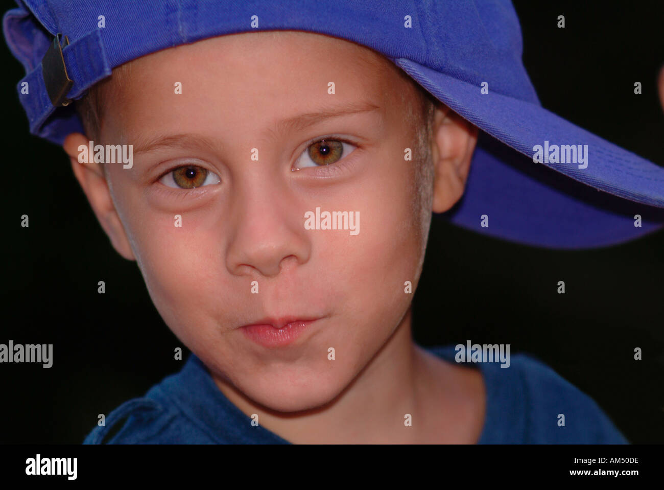 young boy in a blue baseball hat turned sideways Stock Photo Alamy