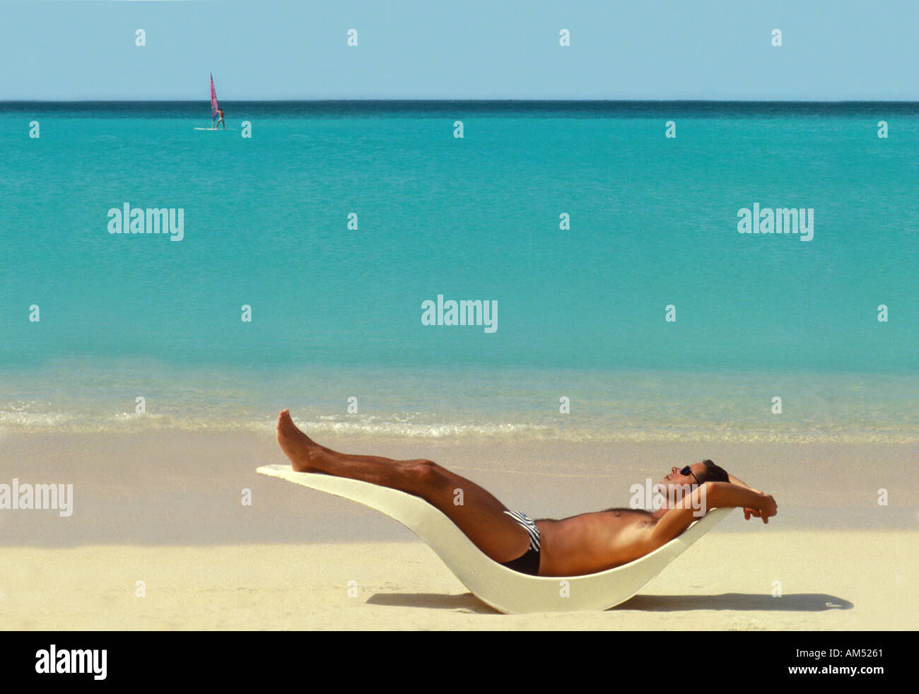 man suns himself on a tropical beach in the Caribbean. Stock Photo