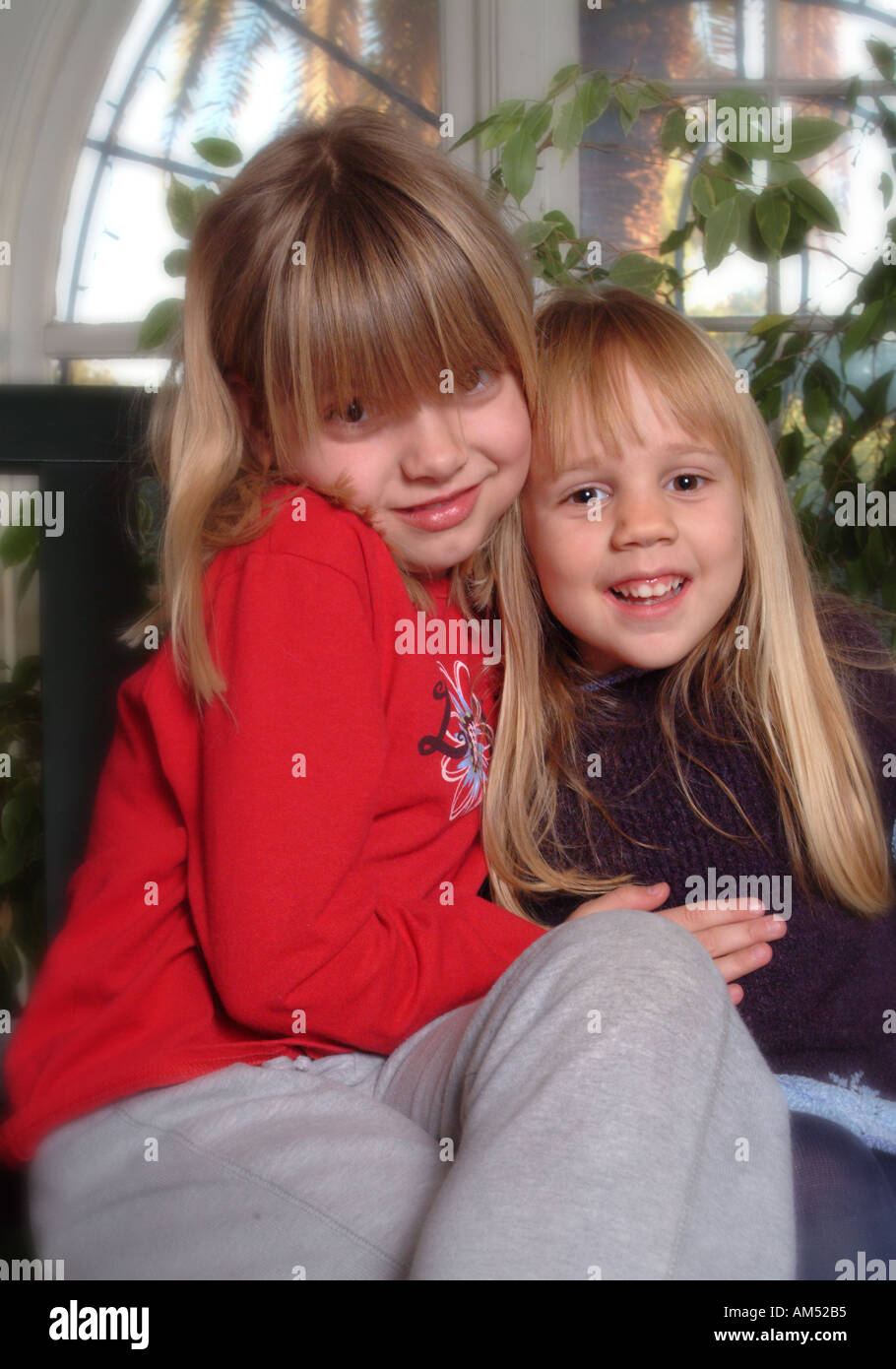 two young blond girls who are best friends pose for a portrait. Stock Photo