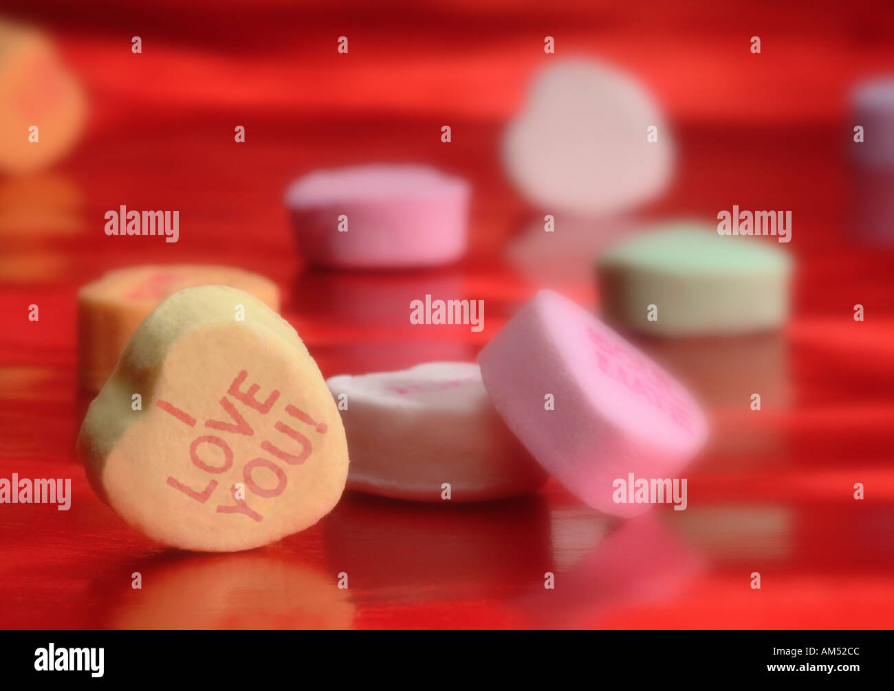 handful of heart shaped Valentine candy with messages printed on them Stock Photo
