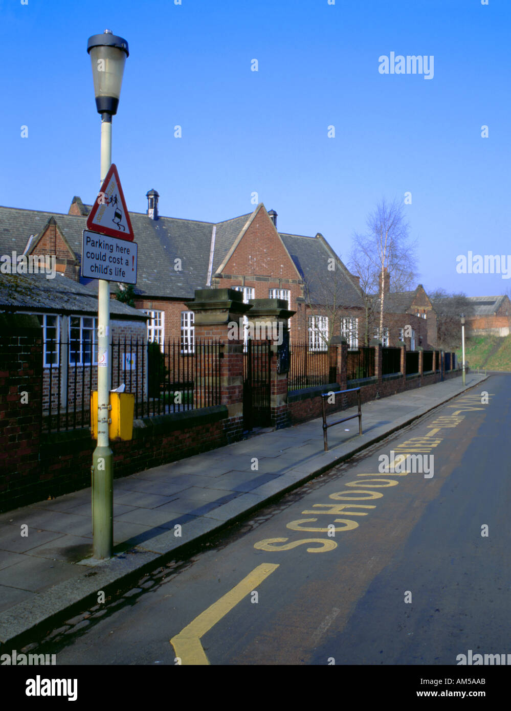 School keep clear road markings and signs on a lamppost outside a school, Jesmond, Newcastle upon Tyne, England, UK. Stock Photo