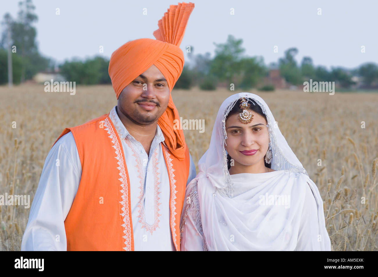 Portrait of a young couple standing in a wheat field Stock Photo - Alamy