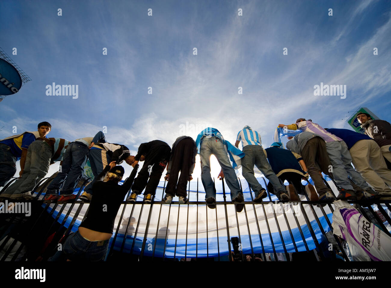 Fans climb the high steel fence around the obelisk on Plaza de La República in Buenos Aires celebrating a 6-0 victory Stock Photo