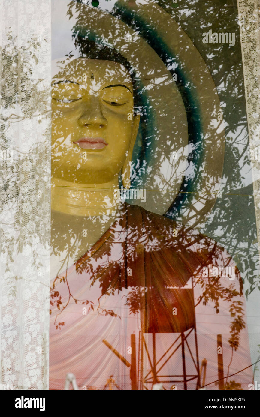 Sri Lanka, Colombo Harbour.  The reflection of a military watchtower in the glass of a roadside shrine for the Buddha. Stock Photo