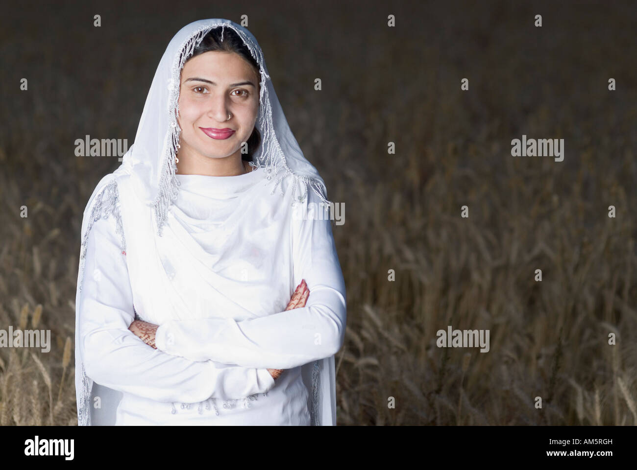 Portrait of a young woman standing in a wheat field Stock Photo - Alamy