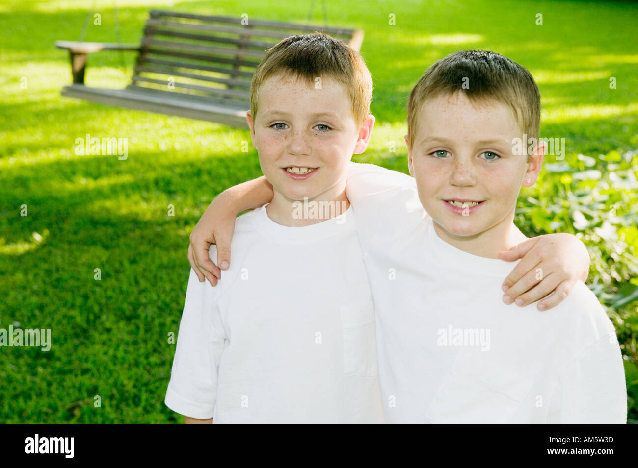 Two boys with arms around each other hi-res stock photography and ...