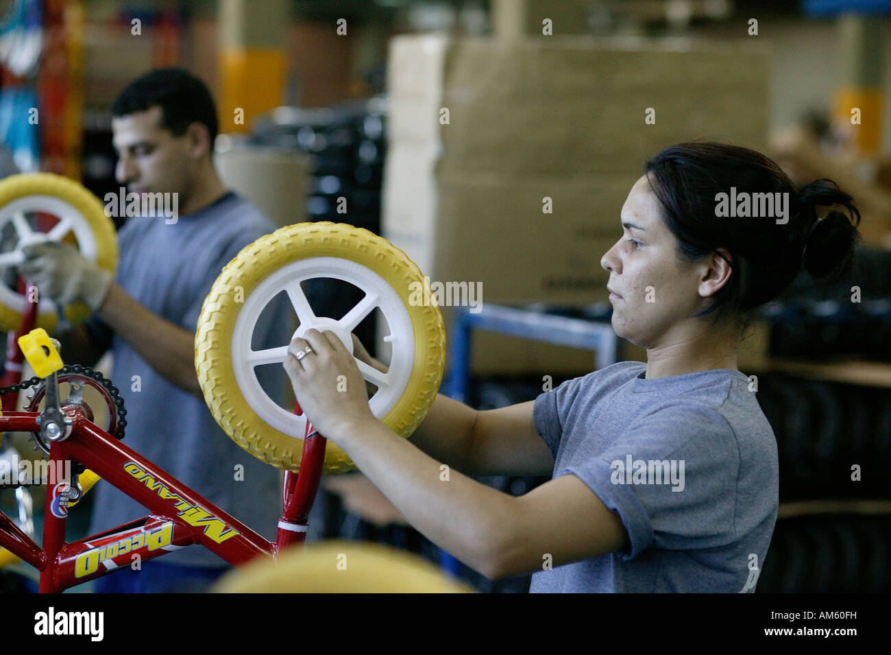 Woman testing children's bicycles in a factory, Asuncion, Paraguay, South America Stock Photo