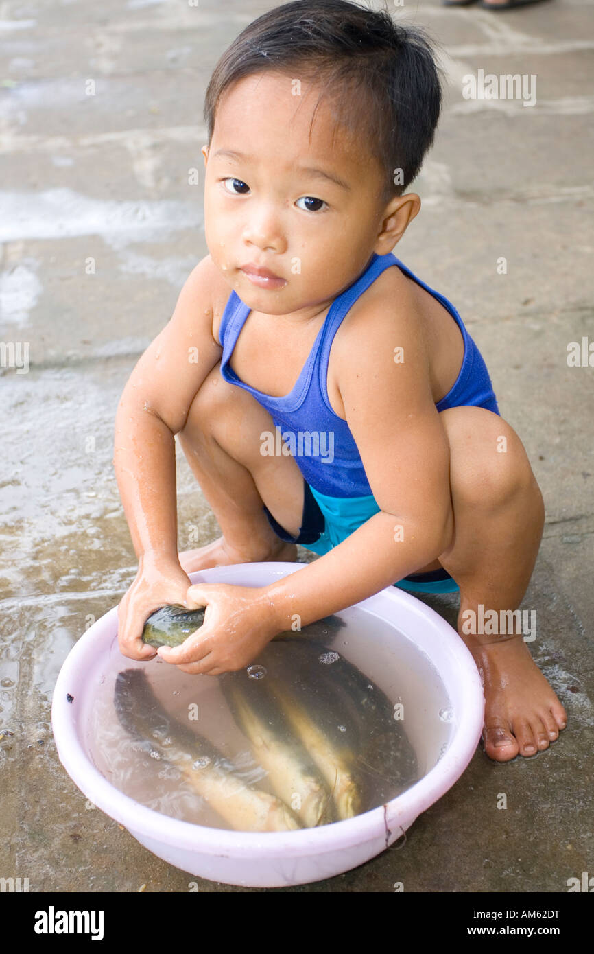 Vietnamese child playing with dead fish, Mekong Delta, Vietnam Stock Photo