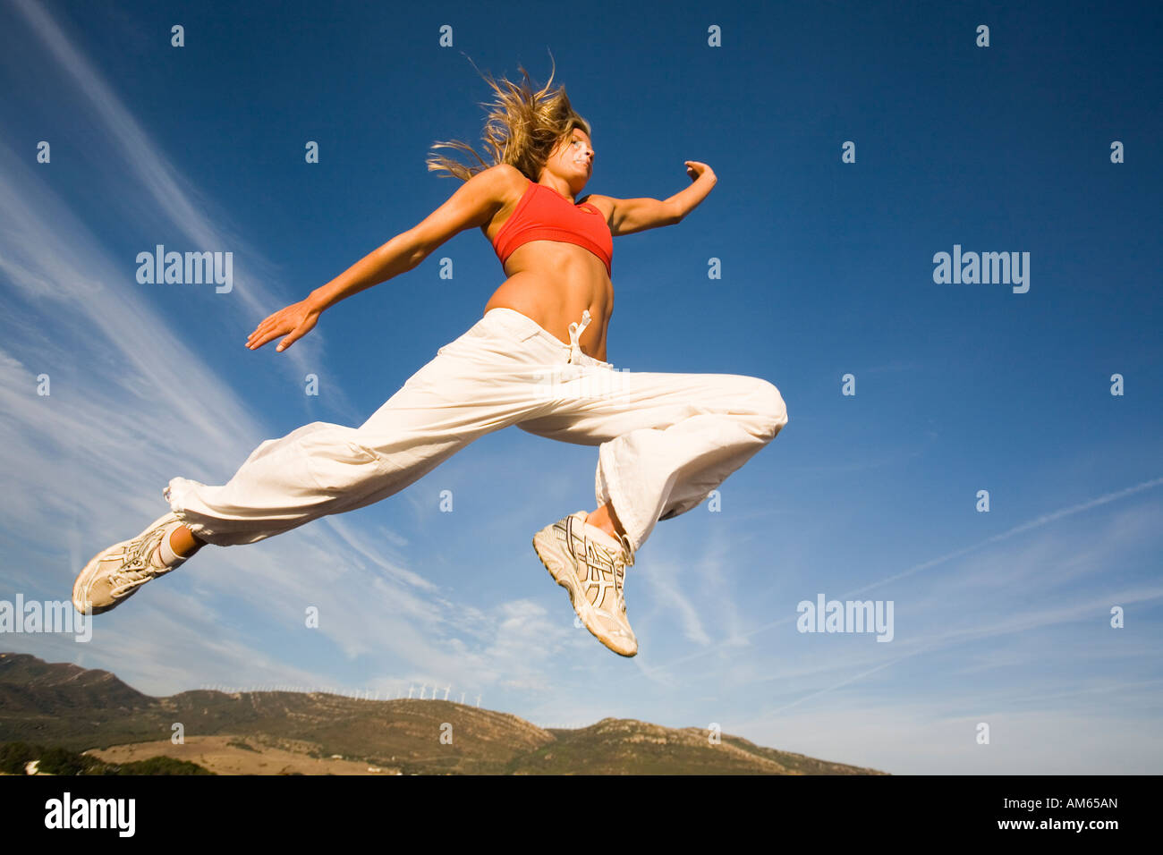 woman jumping into blue sky Stock Photo - Alamy