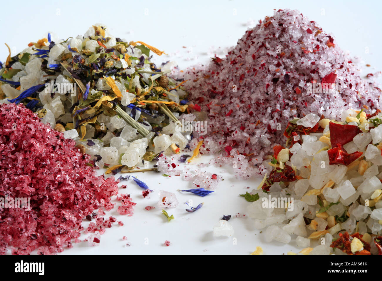 Colourful sea salts, with several spices and herbs like hibiscus, rose petals, chili and paprika Stock Photo