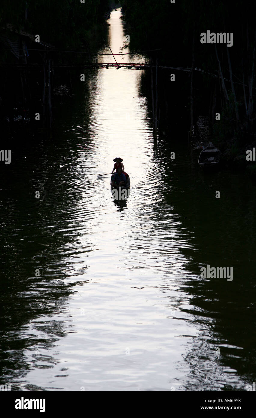 man woman boat paddle river Vietnam Vietnamese light dusk mekong delta Asia Asian trees canal