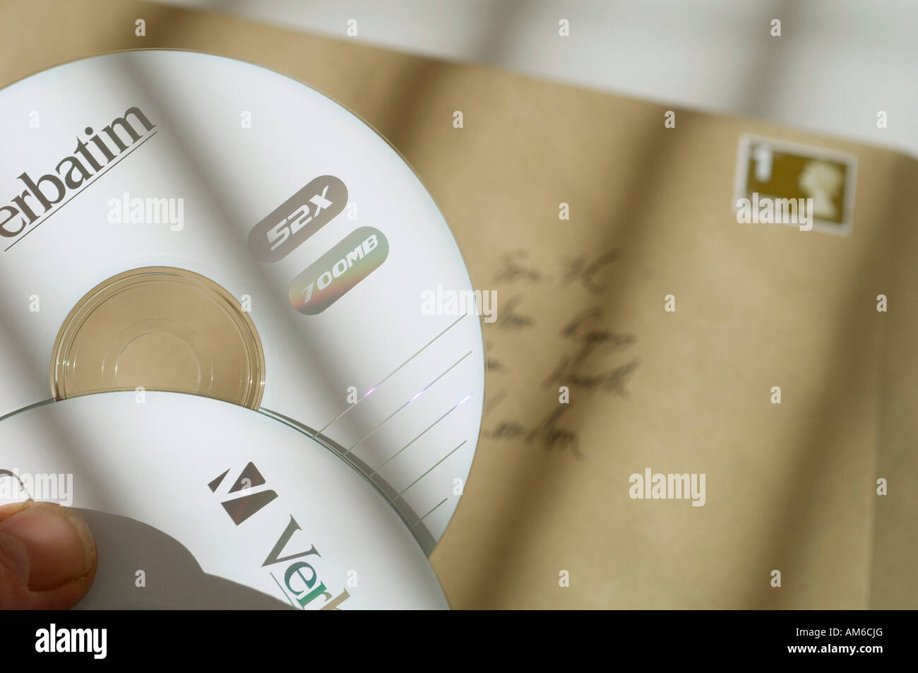 Two verbatim CD computer data discs being put in an envelope. Stock Photo